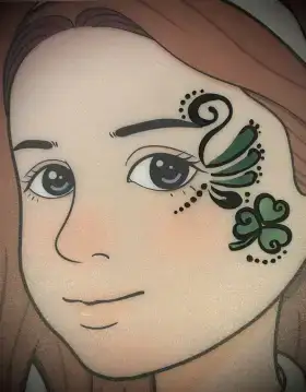 Shamrock eye face painting design with green swirls and gold dots.