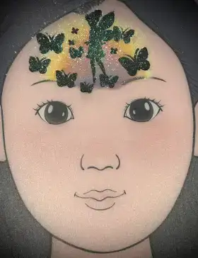 Butterfly fairy silhouette crown face painting design with warm sunset colors across the forehead.