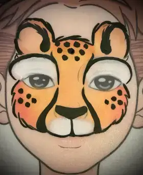 Cheetah face painting mask with golden spots and black outlines around the eyes.